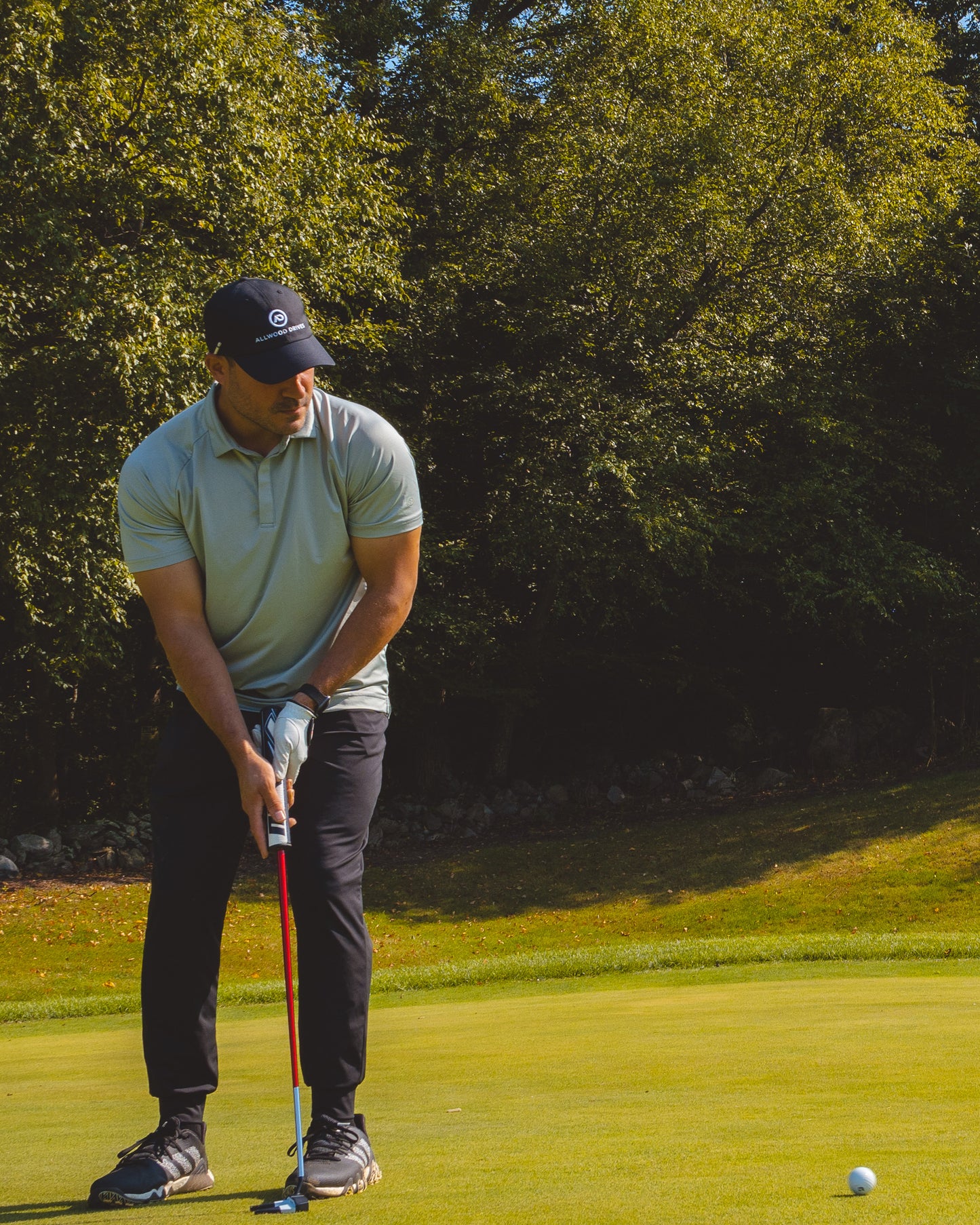 Man playing on golf course in green polo