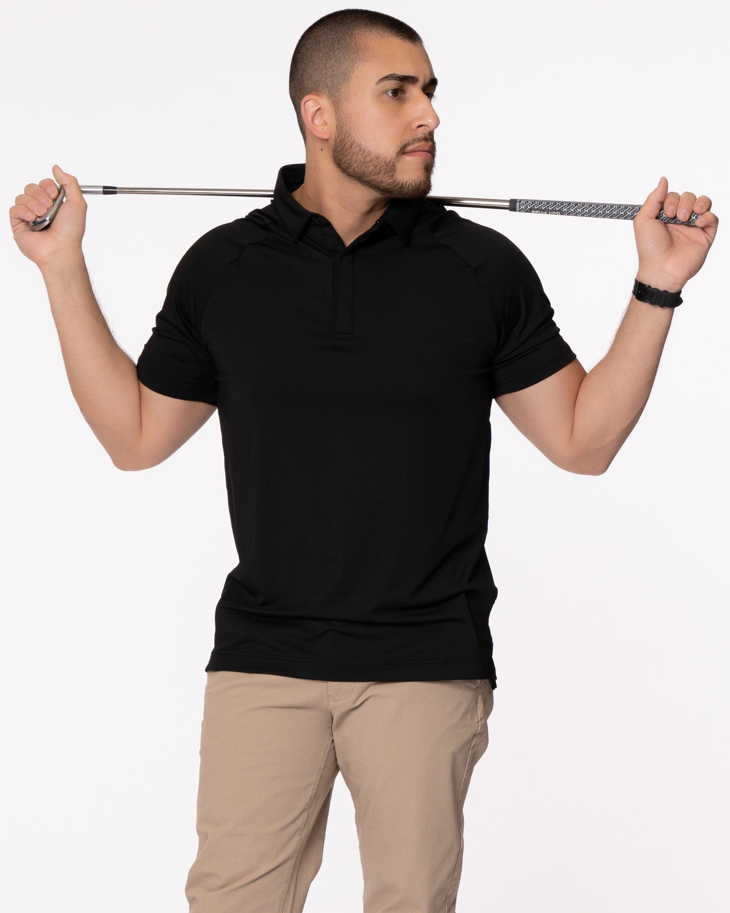 Man holding a golf club in a black polo