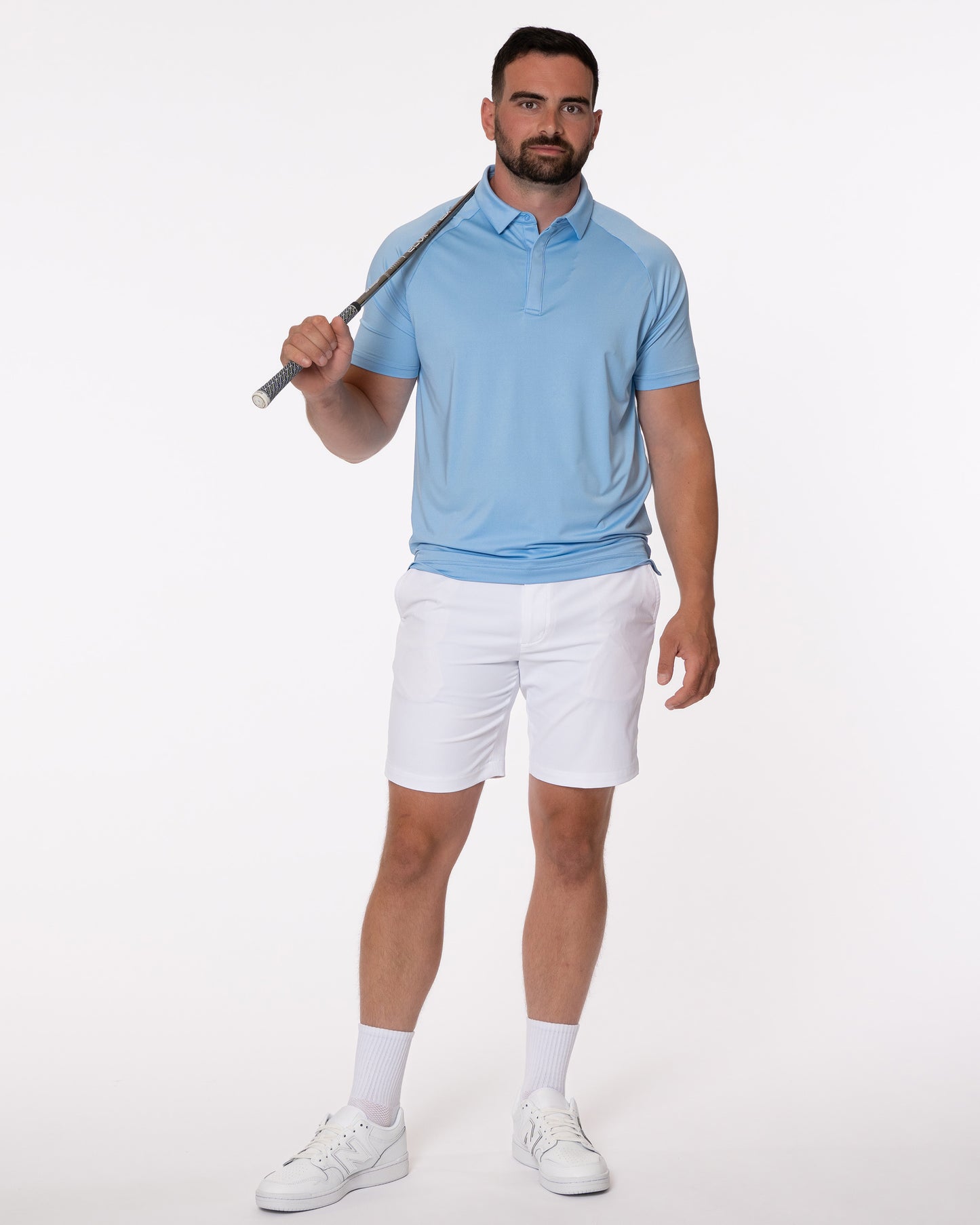 Man in blue golf polo holding a golf club