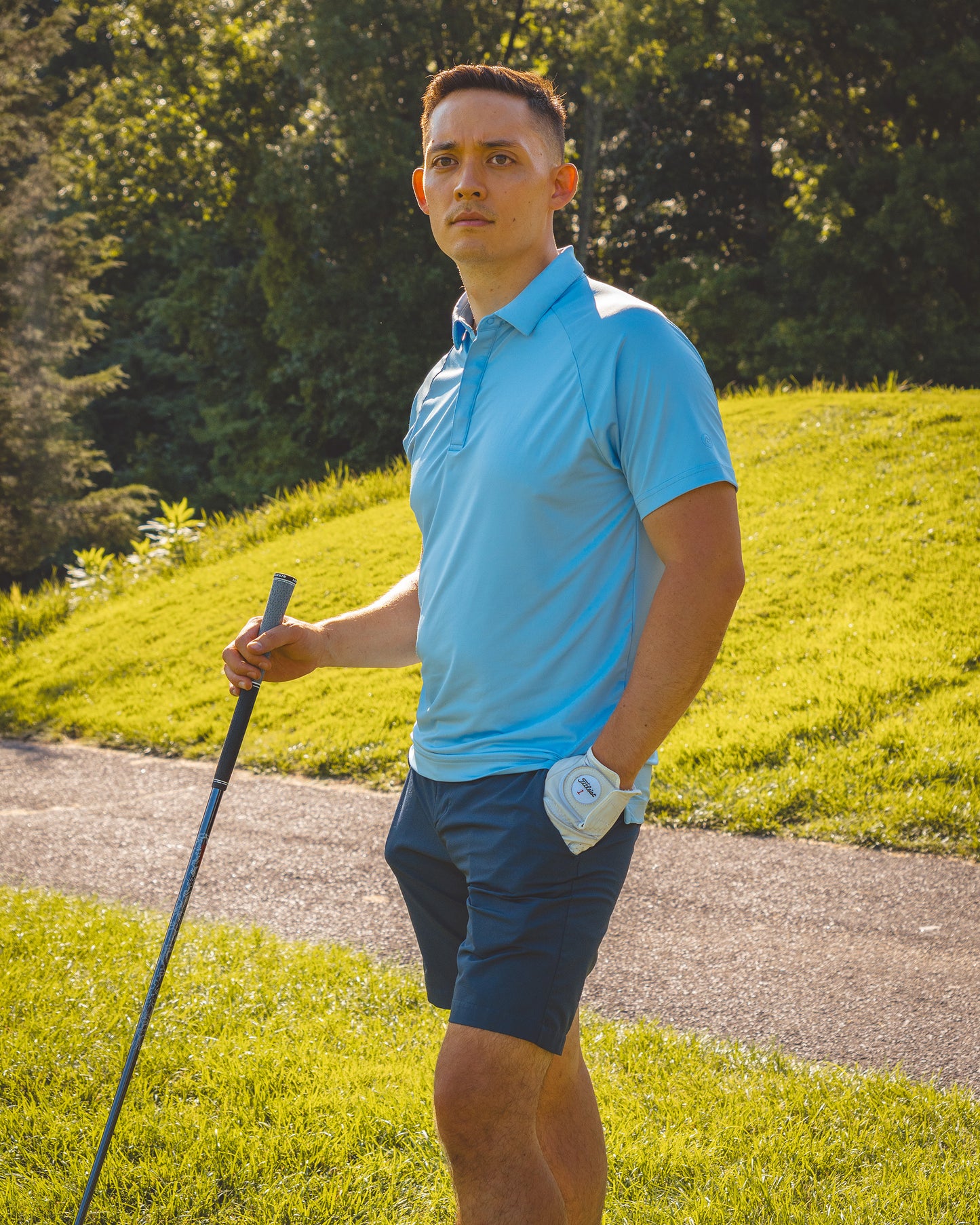 Man on a golf course wearing a blue polo