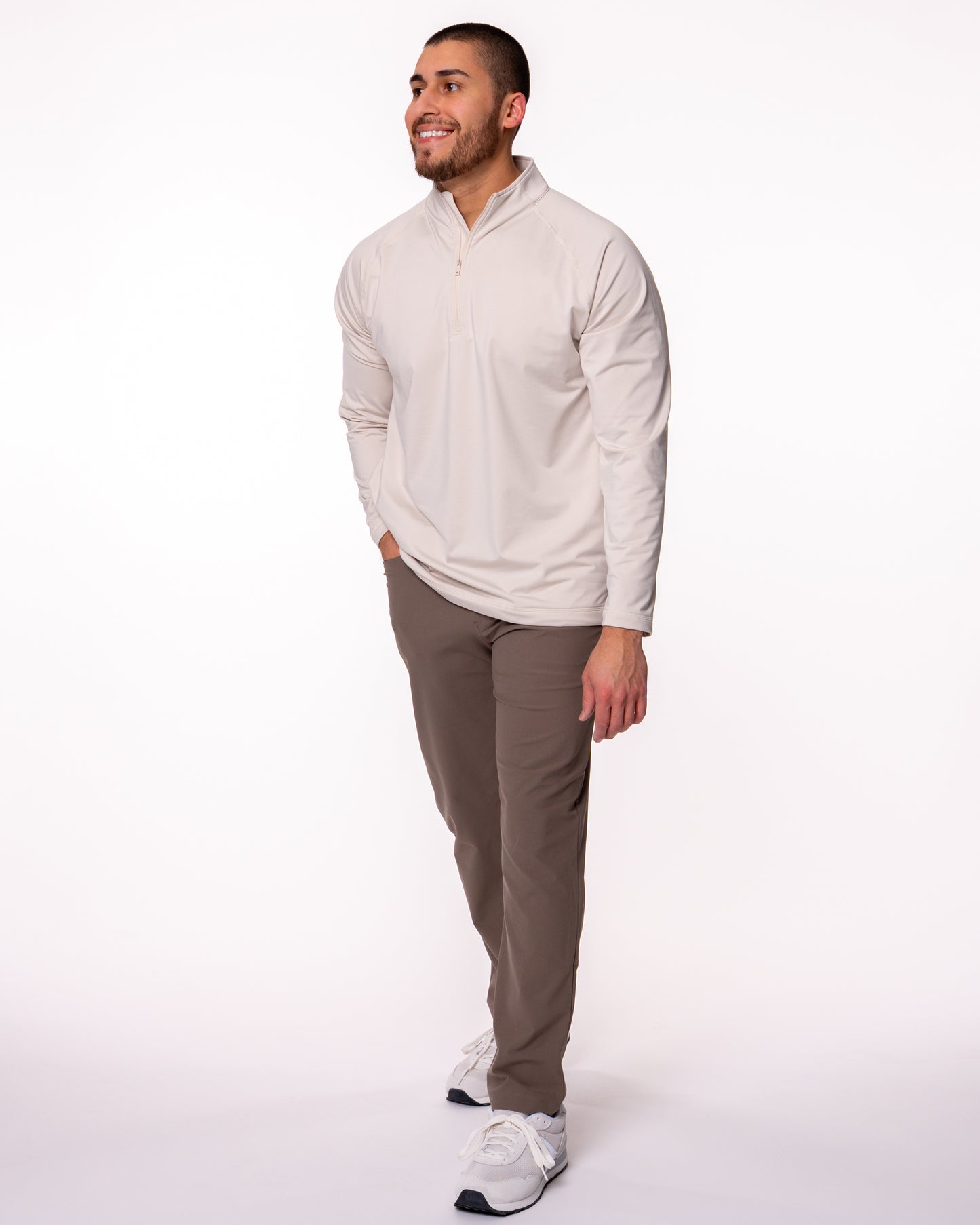 Man smiling wearing a beige quarter zip shirt