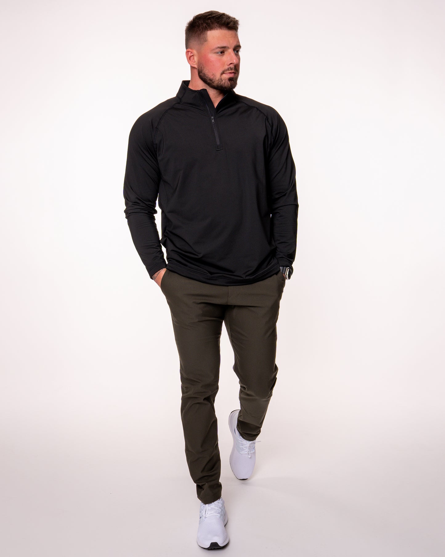 Man walking wearing a black quarter zip shirt